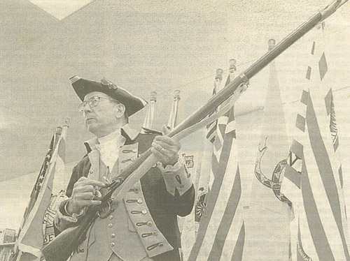 Robert Grover, a volunteer flag preserver and historian of the Revolutionary War, provides a “A Lesson In History”.  Grover explained to children at the Lone Jack branch of the Mid-Continent Public Library, how soldiers used their muskets. Grover has been passing on part of history for over 11 years.  (Source:  The Kansas City Star, Saturday, January 17, 2004)
