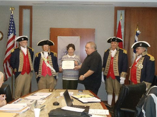 President Donald Lewis and the Harry S. Truman Color Guard, are shown here presenting a Certificate of Appreciation to Mrs. Carolyn Grover, who gave a presentation on their recent trip to Gettysburg, Mt. Vernon and Ft. McHenry. They were accompanied by Compatriot David McCann. President Donald Lewis presented Carolyn Grover with a Certificate of Appreciation and a chapter challenge coin.