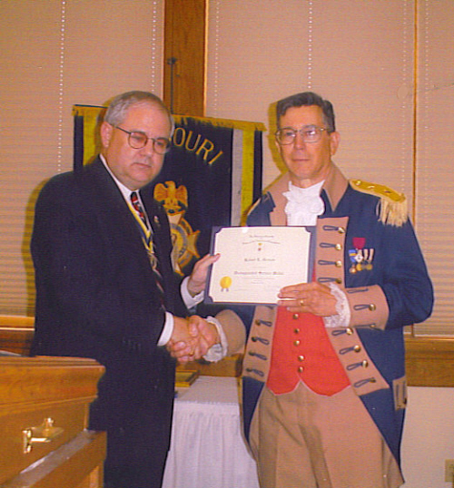 President David N. Appleby presents the Distinguished Service medal and certificate to Robert L. Grover, MOSSAR Color Guard Commander, for his tireless efforts in support of the Color Guard at the 112th MOSSAR Annual State Meeting in Columbia, MO on April 29, 2002